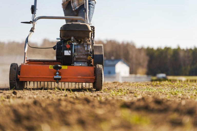 Closeup shoot of man using aerator machine to scarification and aeration of lawn or meadow