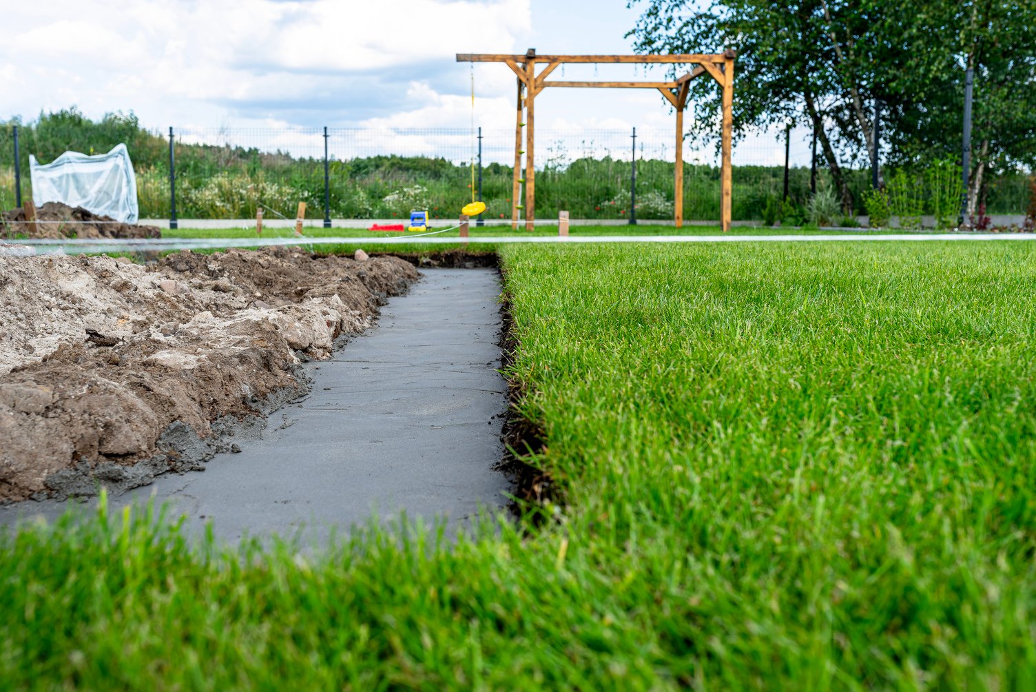 Foundation footings poured in a ditch in the yard, building a terrace in the backyard.